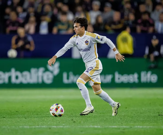Jugador de futbol con una pelota en el cesped